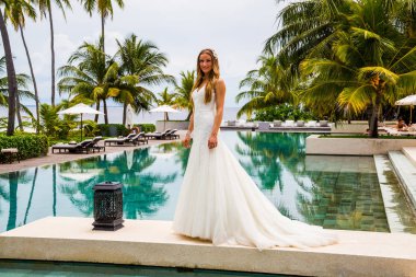 Güzel gelin bir seksi gelinlik havuzun yanında ayakta