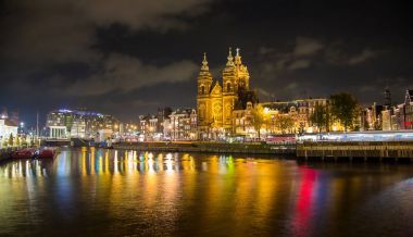 Gece şehir görünümünü Amsterdam kanal ve Basilica Saint Nicholas, Felemenk, Hollanda. Uzun panoramik çekim. Şaşırtıcı görünümü. Gece, sonbahar.