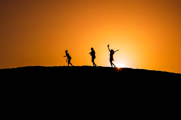 Люди силуэт на вершине дюн Маспаломас — стоковое фото
