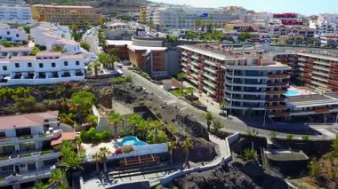 Los Gigantes kenti yakınlarındaki uçurumların üzerinden uçan. Şehre yukarıdan havadan görünümü.