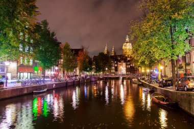 Amsterdam gece Caddesi'nde. Kanalları ile pek çok farklı ışık ve bir kilise vasıl belgili tanımlık son. Güzel bir akşam.