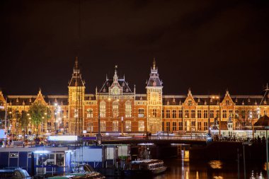 Aziz Nikolaos Kilisesi ve Amstel Nehri manzaralı ışıkları su yansıma ile gece, Amsterdam, Hollanda