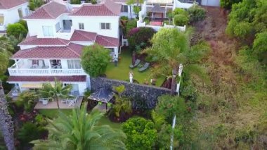 Ondan uzak uçan uçak ise Tenerife adasında villa tarafından oturan bir genç bayan. Güzel manzara yukarıdan ada ve uçurumun kenarında villa.