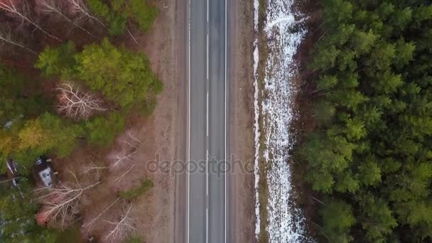 Vidéo aérienne de la forêt d'aiguilles profondes au Canada avec un passage routier à travers elle et même un cimetière pendant l'hiver .