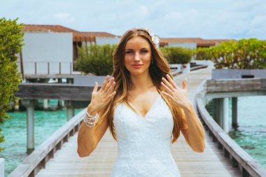 Maldivler bir iskelede uzun seksi beyaz elbise ayakta güzel gelin