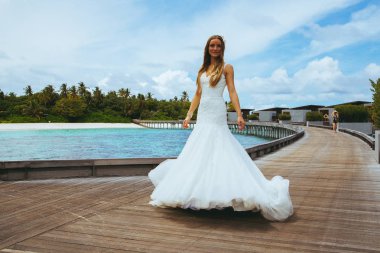 Maldivler bir iskelede uzun seksi beyaz elbise ayakta güzel gelin