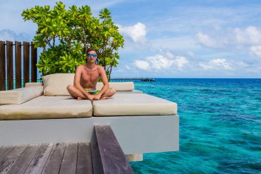 Rahat ve neşeli. Açık denize yakın güvertede dinlenme mutlu genç adam portresi.