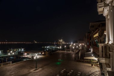 Venedik sokak şehir ışıkları her yerde ile Laguna Veneta yakınındaki güzel karanlık gecede. Otel balkondan şu kıyı şeridi tarafından görüntülemek.