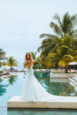 Güzel gelin bir seksi gelinlik havuzun yanında ayakta