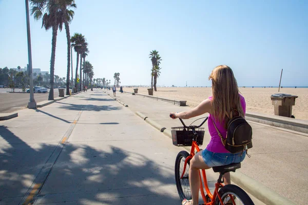 Genç güzel kız Los Angeles'taki Venedik plaj aşağı Bisiklete binmek. Kaliforniya rüya.