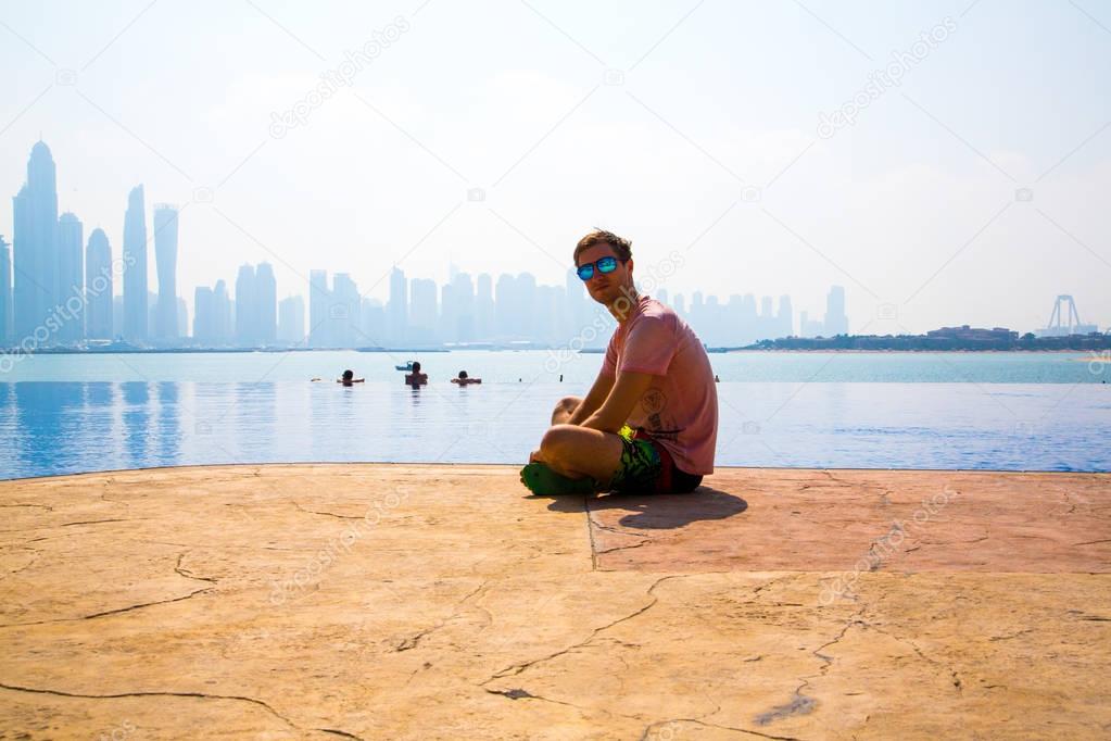 man sitting by the infinity pool