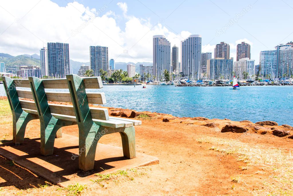 Waikiki beach resort and marina in Honolulu, Hawaii, USA. Scenic view of the Waikiki resort and marina with a bench on a foreground.