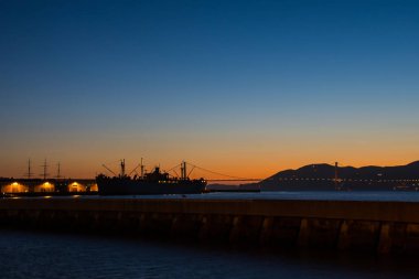 San Francisco Körfezi Köprüsü ve Alcatraz cezaevi içinde belgili tanımlık karanlık ile geç gün batımı görünümü