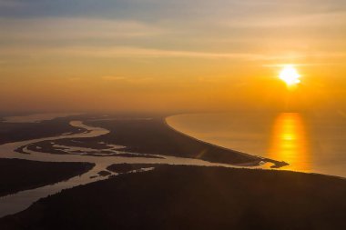 Güzel gün batımı manzarası denize ve sahil şeridine bir nehir banka tarafından