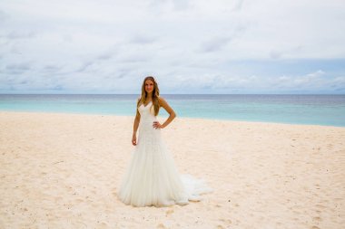 Okyanusun içinde belgili tanımlık geçmiş ile tropikal bir plajda güzel gelin