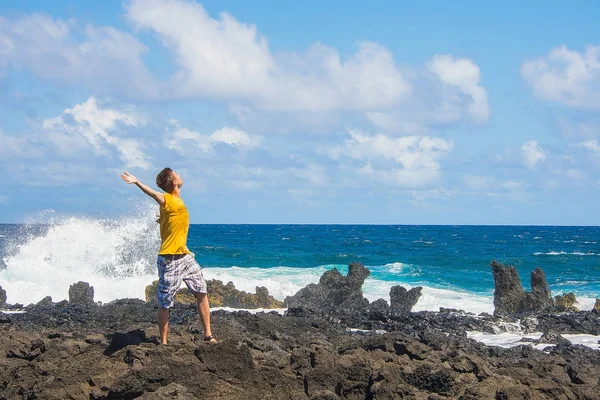 Ayakta duygu onun özgürlük ve hayatta başarı bir kayalık Plajı'nda genç adam
