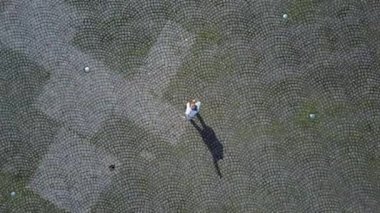 Kız kare sallayarak ve onun alanı gösterilen uzak uçan bir dron ortasında ayakta.