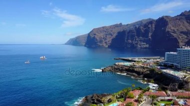Tenerife sahil şehri Los Cristianos Los Gigantes kayalıklarla tarafından güzel havadan görünümü. Binalar ve kayalıklarla sahilinde görüntüleyin. 