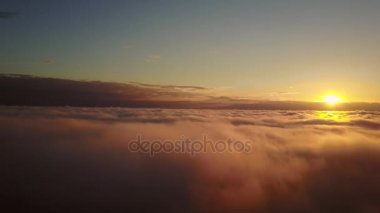 Bulutların arasından yükselen gökyüzü ve gün batımı. Gün batımı sırasında bulutların üstünde uçan