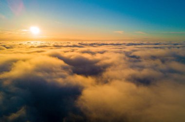 Bulutların üstten günbatımı sırasında güzel havadan görünümü. Sonsuz dünya Güzellik.