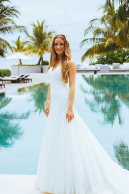 Güzel gelin bir seksi gelinlik havuzun yanında ayakta