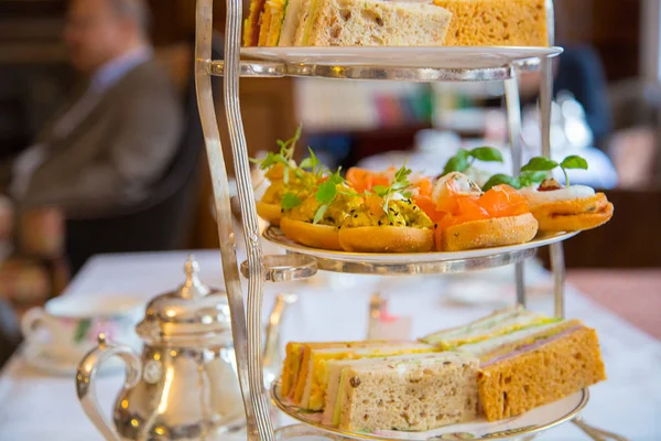 Classical afternoon tea ceremony in London with snacks and sandwiches. Traditional English breakfast style.