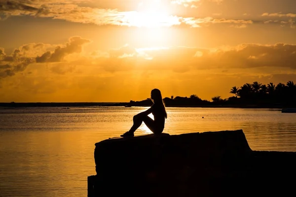 Силуэт Красивой Девушки Сидящей Берегу Наблюдающей Закатом Восходом Солнца — стоковое фото