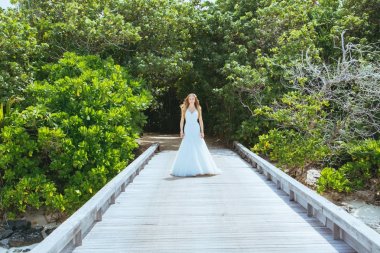 Maldivler bir iskelede uzun seksi beyaz elbise ayakta güzel gelin