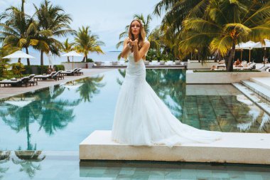 Güzel gelin bir seksi gelinlik havuzun yanında ayakta