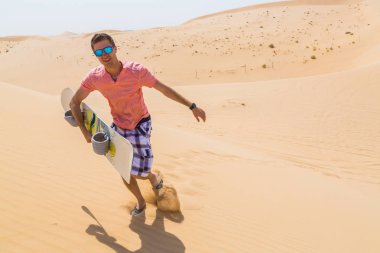 Adam bir snowboard kabuklarıyla bir çölün ortasında ile ayakta