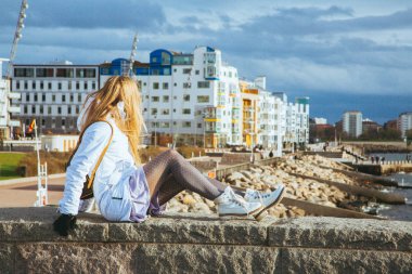 Girl sitting at the Vastra Hamnen district in Malmo clipart