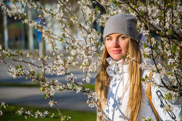 Ragazza in piedi vicino al ciliegio albero di fiori — Foto Stock