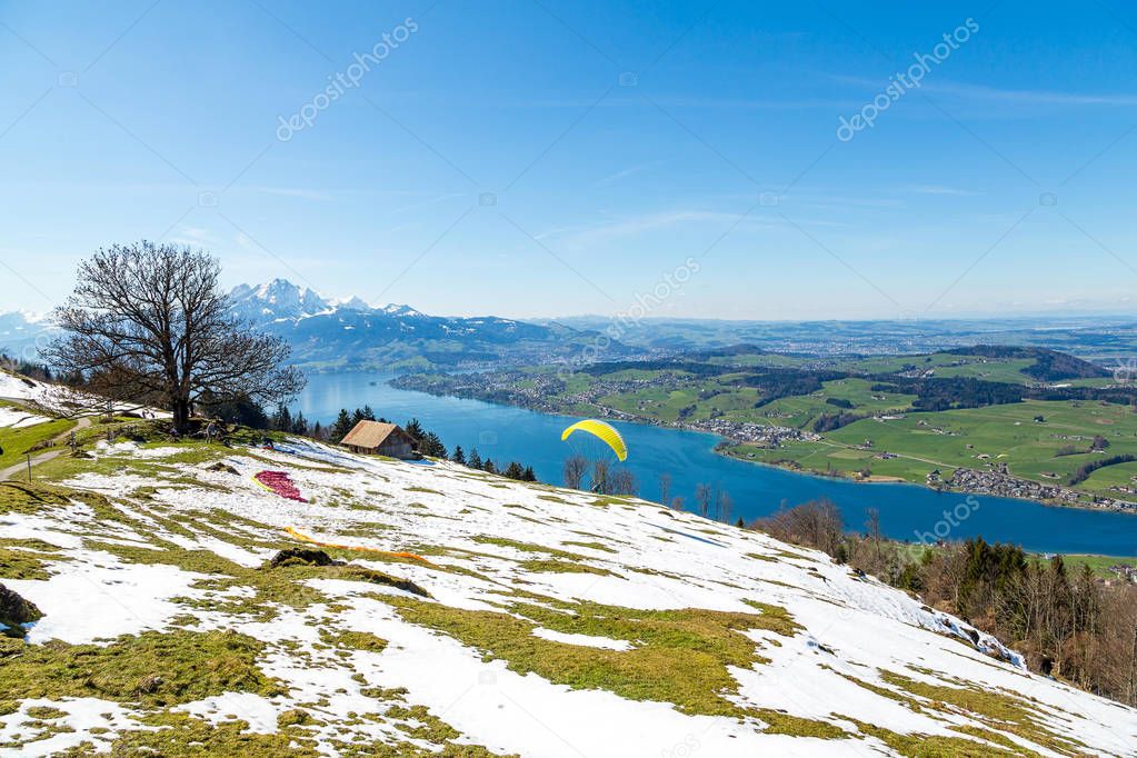 Beautiful nature view in the mountains with people paragliding over the lake
