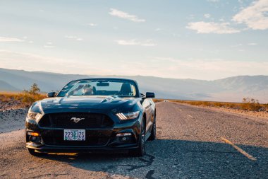 Siyah Ford Mustang Gt convertible sonsuz uzun yolun ortasında bir ölüm Vadisi Nevada, ABD tarafından duruyor. 30 Ağustos 2017.