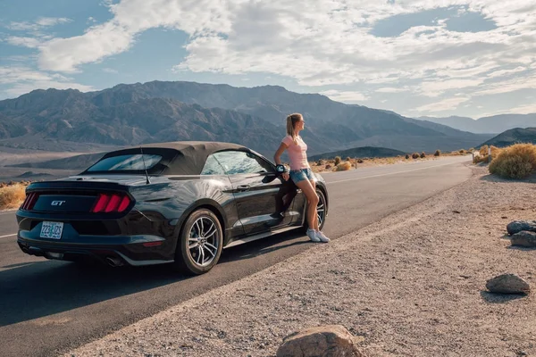 Young Girl Standing Black Ford Mustang Convertible Side Road Nevada Stock Photo