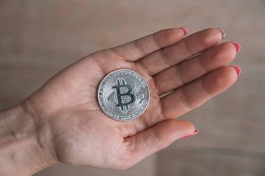 Bir elinde Bitcoin gümüş sikke