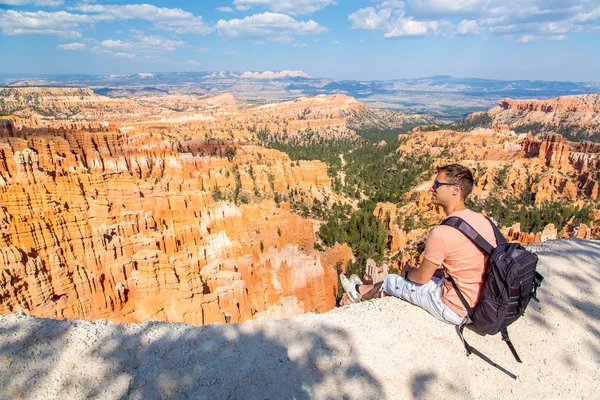 位于美国犹他州布莱斯峡谷国家公园的迷人红砂岩石林风景秀丽的年轻人坐在那里 — 图库照片