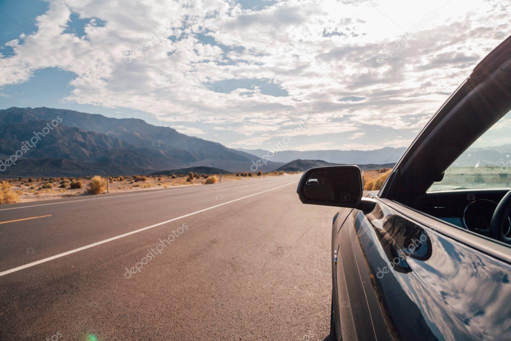 Driving in a black Ford Mustang GT through the Death valley in Nevada. Amazing road trip adventure. August 10, 2017, USA.. 