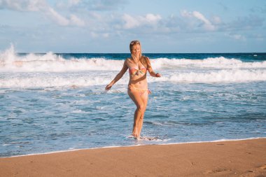 Bir yüzme takımı plaj aşağı Kauai Adası üzerinde koşan genç kız