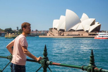 Genç adam tarafından Avustralya'da Sydney Opera Binası. 30 Ağustos 2017. 