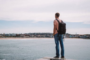 Genç adam Bondi beach kayalıklardan yakınındaki Sydney Avustralya'da keşfetmek. Doğa hiking.