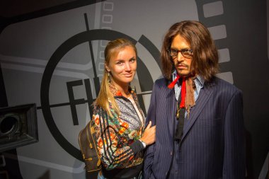 Girl standing by the Johnny Depp wax figure at Madame Tussauds in Sydney Australia as on 17 Jan 2017 clipart