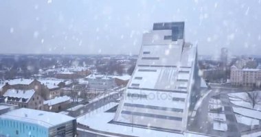20 Ocak 2018. Riga, Letonya. Riga, Letonya Milli Kütüphane kışın üzerinden hava görünüm. Riga kar yağışı ağır. Kasaba ve Kütüphane üzerinde uçan.