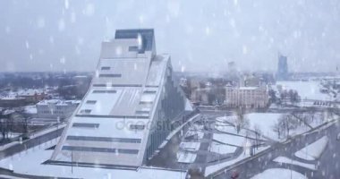 20 Ocak 2018. Riga, Letonya. Riga, Letonya Milli Kütüphane kışın üzerinden hava görünüm. Riga kar yağışı ağır. Kasaba ve Kütüphane üzerinde uçan.