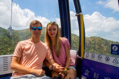 30 Ağustos 2017. Hong Kong, Çin. Hong Kong Lantau Island teleferik Buda yola oturan genç Çift