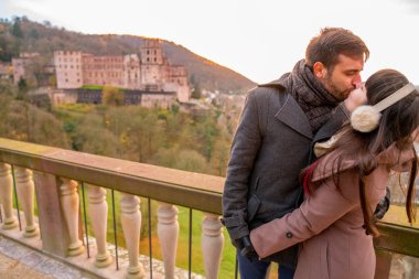 Genç romantik çift öpüşme ve Heidelberg Alman tarihi kentin muhteşem manzaranın. 
