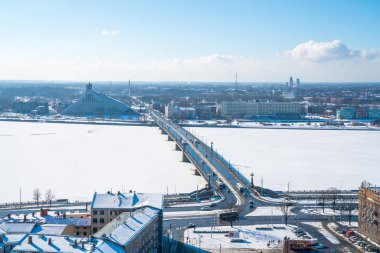 Riga, Letonya. 10 Ocak 2018: Pazar ve Milli Kütüphane manzaralı Riga'da Daugava Nehri Kış saati sırasında köprünün havadan görünümü.