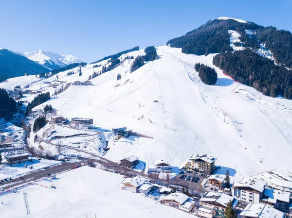 在阿尔卑斯的冬天村庄全景日出看法与滑雪胜地倾斜 — 图库照片