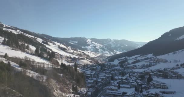 スキー場 ケーブルカー スノーボーダーがあるアルプスの真ん中にあるオーストリアの小さな冬の町の美しい空の景色 — ストック動画