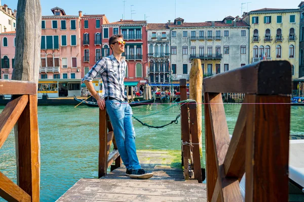 Venedik, İtalya. 10 Nisan 2018. Venedik keşfetmek bir genç adam. Rialto Köprüsü yanı sıra San Marco Meydanı geçirerek gondol izlerken Kanallar başına oturmuş. 